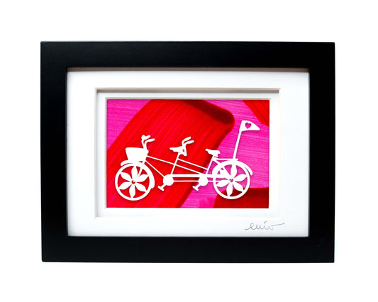 White tandem couples bike with heart flag papercut on hand painted pink and red background.